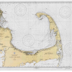 May include: A vintage nautical chart of Cape Cod Bay, Massachusetts. The chart features detailed coastline, waterways, and navigational information. The chart is printed on a cream-colored paper with black and blue lines.