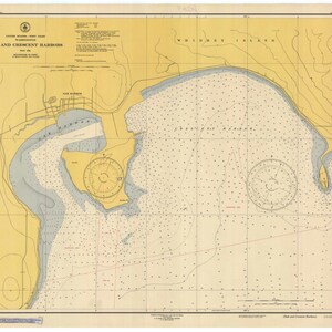 May include: A vintage nautical chart of Oak and Crescent Harbors in Washington State. The chart is printed on yellowed paper and shows the coastline, waterways, and depths of the harbors. The chart also includes a compass rose and a scale bar.