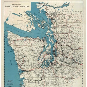 May include: A vintage map of Puget Sound Country from 1919, showing the region's geography, including the Puget Sound, the Olympic Mountains, and the Cascade Range. The map also shows major cities, towns, and roads.