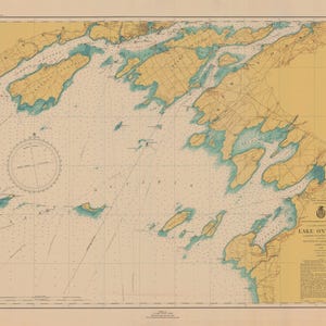 May include: A vintage nautical chart of Lake Ontario, showing the shoreline and islands in detail. The chart is printed on a cream-colored paper with blue and green accents. The chart includes a compass rose and a legend.