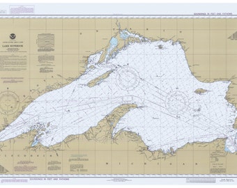 以下が含まれることがあります： スーペリア湖の海図で、深さがフィートとファゾムで示されています。海図には、コンパスローズ、スケールバー、さまざまな航海用具が含まれています。海図はベージュの背景に印刷されており、青い線は深さを表しています。