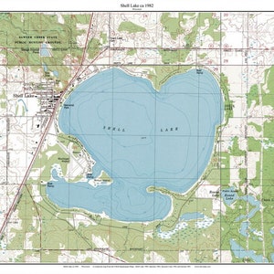 May include: A vintage map of Shell Lake, Wisconsin, from 1982. The map shows the lake, surrounding roads, and nearby towns. The map is in black and white with blue water and green land.