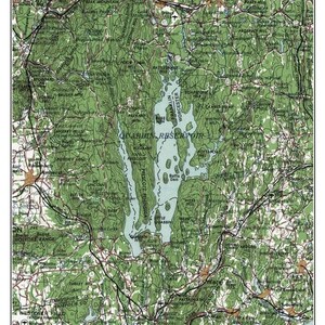 May include: A vintage map of Quabbin Reservoir in Massachusetts, dated 1962. The map shows the reservoir's shape, surrounding towns, and nearby roads. The map is printed in shades of green and blue.