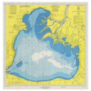 May include: A nautical chart of Lake Saint Clair, showing the shoreline, islands, and depths of the lake. The chart is in blue, yellow, and white, with black lines and text. The title "LAKE SAINT CLAIR" is printed in the upper right corner.