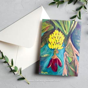 May include: A rectangular greeting card featuring an acrylic painting of a cluster of bright yellow bananas and a deep red banana blossom against a blue and green foliage background. The text "stay golden" is visible, and the artist's signature "MSingleton" is in the bottom left corner.