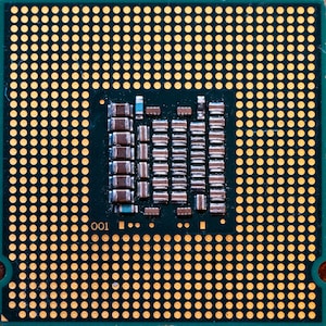 May include: Close-up of a green circuit board with gold-colored contacts. The board has a grid pattern and the number "001" is visible in the lower left corner.