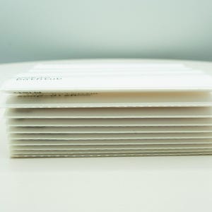 May include: A stack of white paper cards, each with a subtle texture. The top card has the word "EXTEND" printed on it.