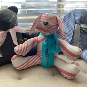 May include: Three handmade plush toys: a black bear with pink ribbon, a pink and white striped bunny with a turquoise ribbon, and a blue and white gingham bunny with a silver ribbon.