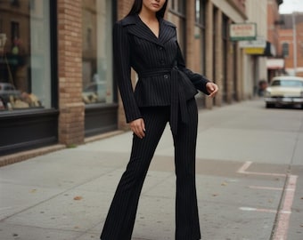 May include: A black pinstriped suit consisting of a long-sleeved blazer with a notched collar, a button-front closure, and a matching tie-waist belt, paired with matching black pinstriped trousers that feature a flared leg silhouette.