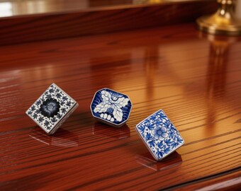 May include: Three small, rectangular and octagonal decorative boxes featuring blue and white floral and botanical patterns. Each box has a distinct design, including a dark blue central flower, a white butterfly motif, and a light blue floral pattern.