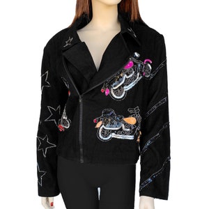 K&ouml;nnte beinhalten: Schwarze Jeansjacke mit Pailletten-Motorrad-Designs und Stern-Akzenten.
