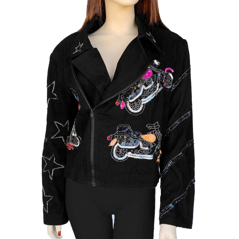 K&ouml;nnte beinhalten: Schwarze Jeansjacke mit Pailletten-Motorrad-Designs und Stern-Akzenten.