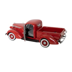 May include: A red 1937 Chevrolet pickup truck model with a white interior and chrome accents. The truck has a wooden bed and is in a classic style.
