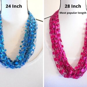 May include: Two crocheted infinity scarves, one in turquoise blue and one in fuchsia pink. The turquoise scarf is 24 inches long and the fuchsia scarf is 28 inches long. The fuchsia scarf is labelled "Most popular length".