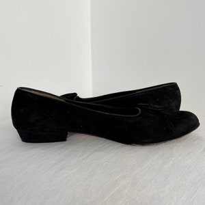 K&ouml;nnte beinhalten: Ein Paar schwarze Wildlederschuhe mit Absatz und einem Quasten-Detail an der Spitze.