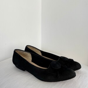 K&ouml;nnte beinhalten: Ein Paar schwarze Wildlederschuhe mit einer Quaste an der Spitze.