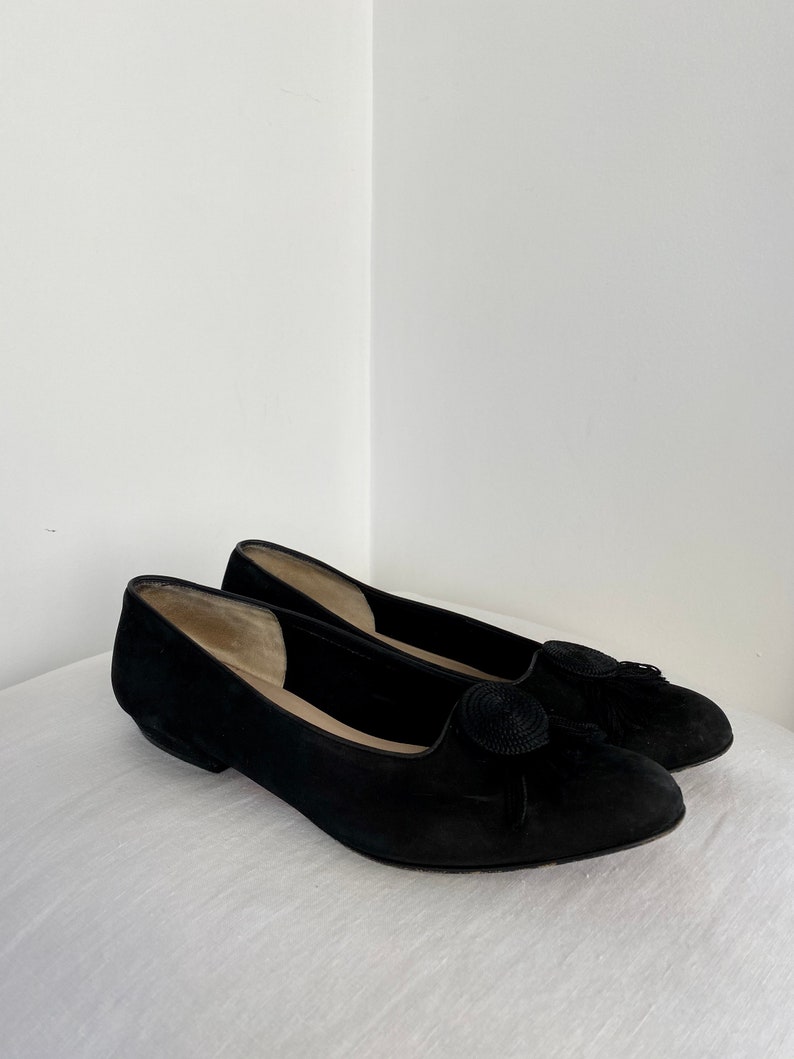 K&ouml;nnte beinhalten: Ein Paar schwarze Wildlederschuhe mit einer Quaste an der Spitze.