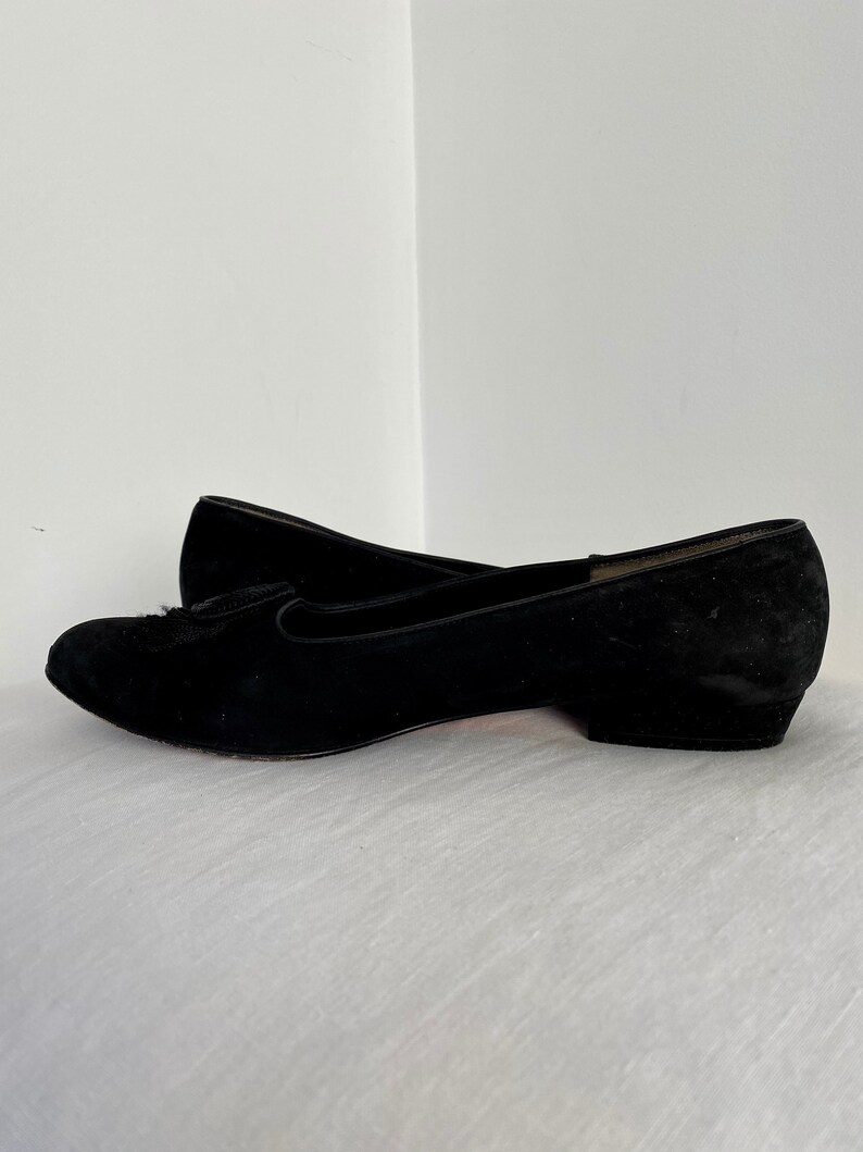 K&ouml;nnte beinhalten: Ein Paar schwarze Ballerinas aus Wildleder mit spitzer Zehenpartie und niedrigem Absatz.