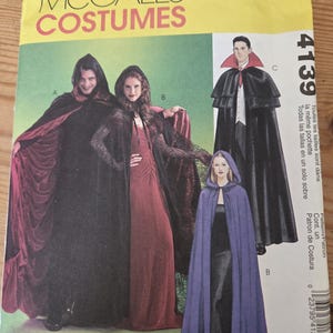May include: A McCall's Costumes sewing pattern envelope, number 4139, featuring illustrations of capes and cloaks. The cover displays three variations of hooded and collared capes in black, red, and purple, with the text Easy 2 Hour printed at the bottom.