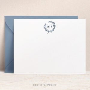 May include: A white stationery card with a blue envelope. The card features a wreath of leaves with the initials "A|S" in the center.