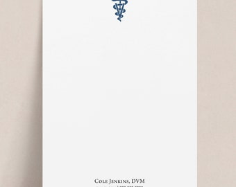 May include: A white notepad with a blue medical symbol at the top and the text "COLE JENKINS, DVM" and "EMAIL.COM | 000.000.0000" at the bottom.