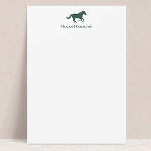 May include: White notepad with a green horse silhouette and the text "Megan Hamilton" at the top.