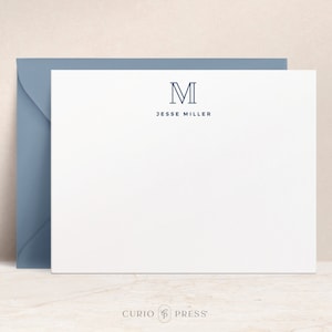 May include: White stationery with a blue envelope. The stationery has a blue monogram of the letter "M" and the text "Jesse Miller". The bottom of the stationery has the text "CURIO PRESS" in blue.