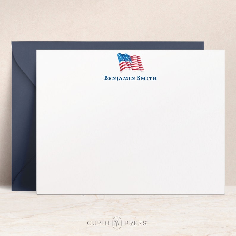 K&ouml;nnte beinhalten: Wei&szlig;e Briefpapier mit einer blauen und roten amerikanischen Flagge Grafik und dem Text "BENJAMIN SMITH" in blau.