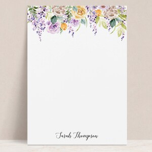 Könnte beinhalten: Weißes Briefpapier mit einem Aquarell-Blumenmuster. Der obere Teil des Papiers zeigt einen Rand aus lila, gelben und braunen Blumen und grünen Blättern. Der Name "Sarah Thompson" ist unten in schwarzer Schrift geschrieben.