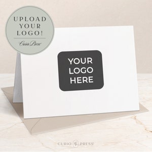 May include: White card with a black square that says "YOUR LOGO HERE" in white text. The card is folded in half and has a gray circle on the left side that says "UPLOAD YOUR LOGO!" in black text. The text "Curio Press" is in a smaller font below the main text.