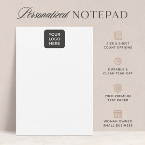 May include: A white notepad with a blank space for a logo. The notepad is on a wooden surface. The text "Personalized Notepad" is at the top of the image. The text "Your Logo Here" is in a box in the upper left corner of the notepad. The right side of the image has four icons with text. The first icon is a sheet of paper with a ruler, and the text "Size & Sheet Count Options". The second icon is a sun with a tear-off sheet, and the text "Durable & Clean Tear-Off". The third icon is a shield with a star, and the text "70lb Premium Text Paper". The fourth icon is a storefront, and the text "Woman Owned Small Business".