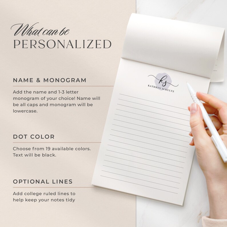 May include: A white notebook with a personalised monogram and name. The notebook has a light pink dot and the text "What can be personalized" at the top. The text "NAME & MONOGRAM" is in black and the text "Add the name and 1-3 letter monogram of your choice! Name will be all caps and monogram will be lowercase." is in black. The text "DOT COLOR" is in black and the text "Choose from 19 available colours. Text will be black." is in black. The text "OPTIONAL LINES" is in black and the text "Add college ruled lines to help keep your notes tidy" is in black. The monogram is "ks" and the name is "KATHRYN SCHULTZ".