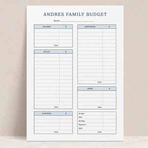 May include: A white paper budget planner sheet titled ANDRES FAMILY BUDGET with a blank line for Month. It features light blue header sections for Income, Expenses, Bills, Debt, and Savings, each with columns for dollar amounts and total rows.