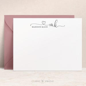 May include: White stationery card with a black cursive font that reads "mk" with a heart above the "k" and "MADISON KLEIN" below. The card is on a light pink envelope.