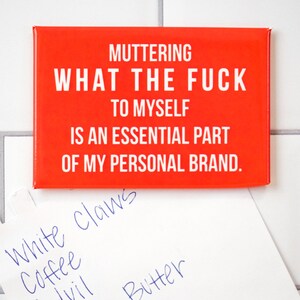 May include: Red rectangular magnet with white text that reads "MUTTERING WHAT THE FUCK TO MYSELF IS AN ESSENTIAL PART OF MY PERSONAL BRAND."