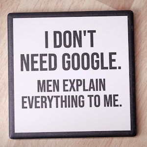 May include: White coaster with black text that reads "I don't need Google. Men explain everything to me."