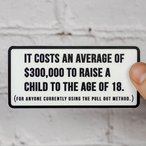 May include: A white sticker with black text that reads "IT COSTS AN AVERAGE OF £300,000 TO RAISE A CHILD TO THE AGE OF 18. (FOR ANYONE CURRENTLY USING THE PULL OUT METHOD.)"
