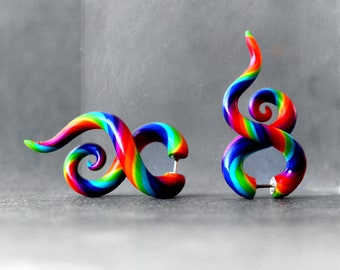 May include: A pair of rainbow colored spiral ear gauges. The gauges are made of polymer clay and have a shiny finish.