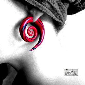 Könnte beinhalten: Ein roter und schwarzer Spiral-Ohrstecker. Der Stecker ist aus Holz und hat eine glänzende Oberfläche.