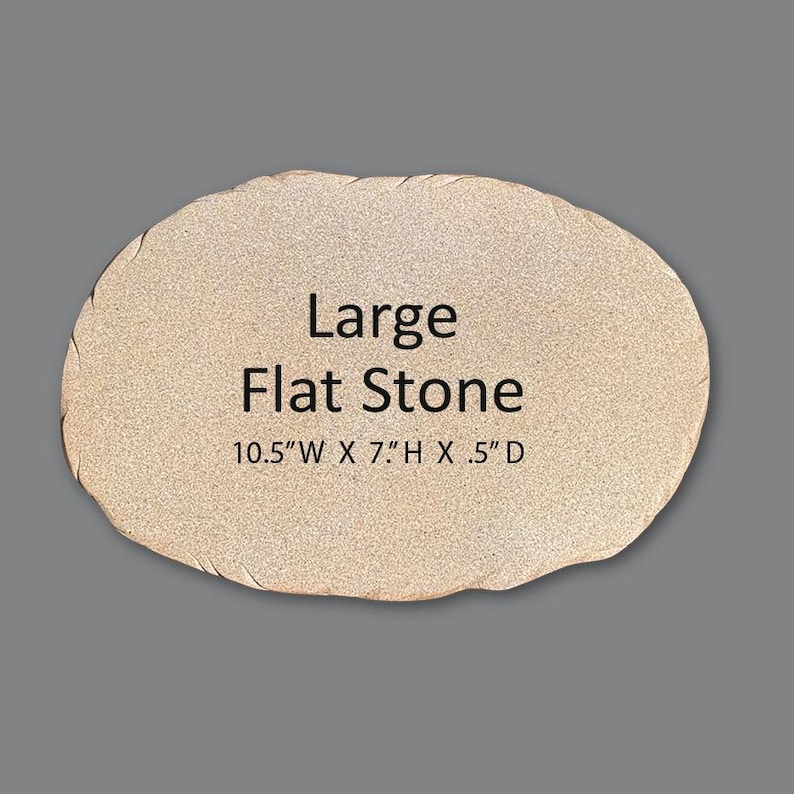 May include: A large, oval-shaped, light beige flat stone with a textured, granular surface. The text "Large Flat Stone" is printed in black in the center, followed by the dimensions "10.5" W X 7" H X .5" D" printed in black below it.