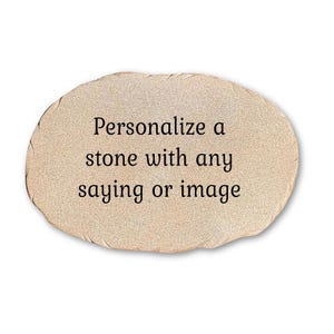 May include: An oval-shaped, light beige stone with a textured, granular surface. The center of the stone features black printed text that reads: Personalize a stone with any saying or image. The edges of the stone are irregular and slightly jagged.