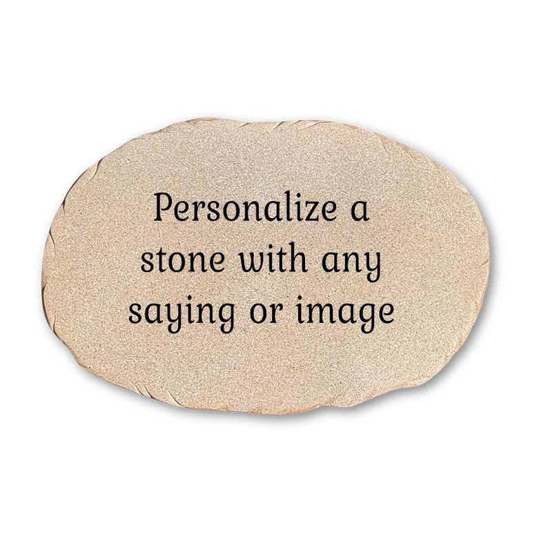 May include: An oval-shaped, light beige stone with a textured, granular surface. The center of the stone features black printed text that reads: Personalize a stone with any saying or image. The edges of the stone are irregular and slightly jagged.