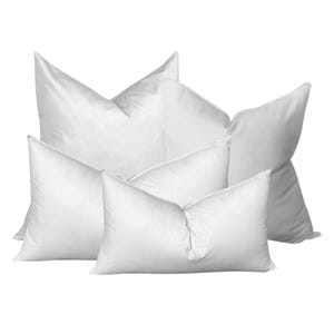 May include: Four white pillows of different sizes stacked on top of each other. The pillows are made of a soft, fluffy material and have a smooth, white fabric cover.