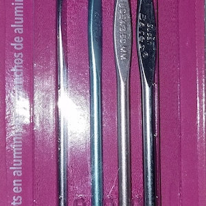 Puede incluir: Un juego de cuatro agujas de crochet de aluminio plateado en un paquete de pl&aacute;stico rosa. Las agujas est&aacute;n etiquetadas con sus tama&ntilde;os: 2,75 mm, 3,25 mm, 3,50 mm y 3,75 mm. El paquete tambi&eacute;n incluye las tallas estadounidenses: C-2, D-3, E-4 y F-5.
