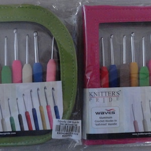Puede incluir: Dos juegos de agujas de crochet en una caja. La caja es verde y rosa. Las agujas son de aluminio y tienen mangos de agarre suave. El texto en la caja dice "Knitters Pride Waves Aluminum Crochet Hooks in Soft Feel Handle".