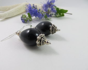 May include: Black gemstone dangle earrings with silver filigree accents.