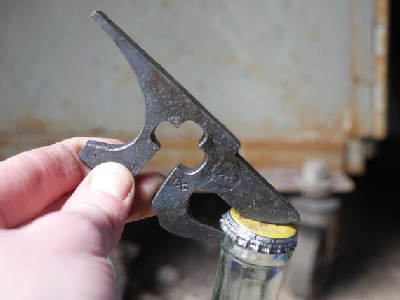 A real blacksmith hammered this cross-shaped bottle opener on an anvil — functional, faith-forward, and carries visible forge marks that prove a human made it.