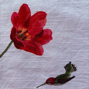 Puede incluir: Primer plano de una tela blanca con un tulip&aacute;n rojo y un colibr&iacute;. El tulip&aacute;n est&aacute; en plena floraci&oacute;n con un centro amarillo. El colibr&iacute; es rojo, verde y negro.