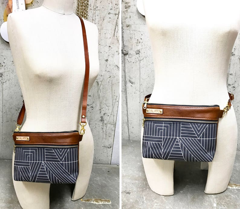 May include: Two views of a brown leather and black fabric crossbody bag with a geometric pattern. The bag has a gold metal buckle and a gold metal name tag that reads "MOLATO".