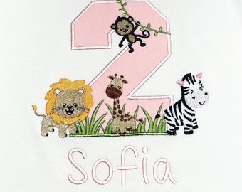 May include: Pink embroidered number two with a monkey, lion, giraffe, and zebra in a jungle scene. The name Sofia is embroidered below the number.
